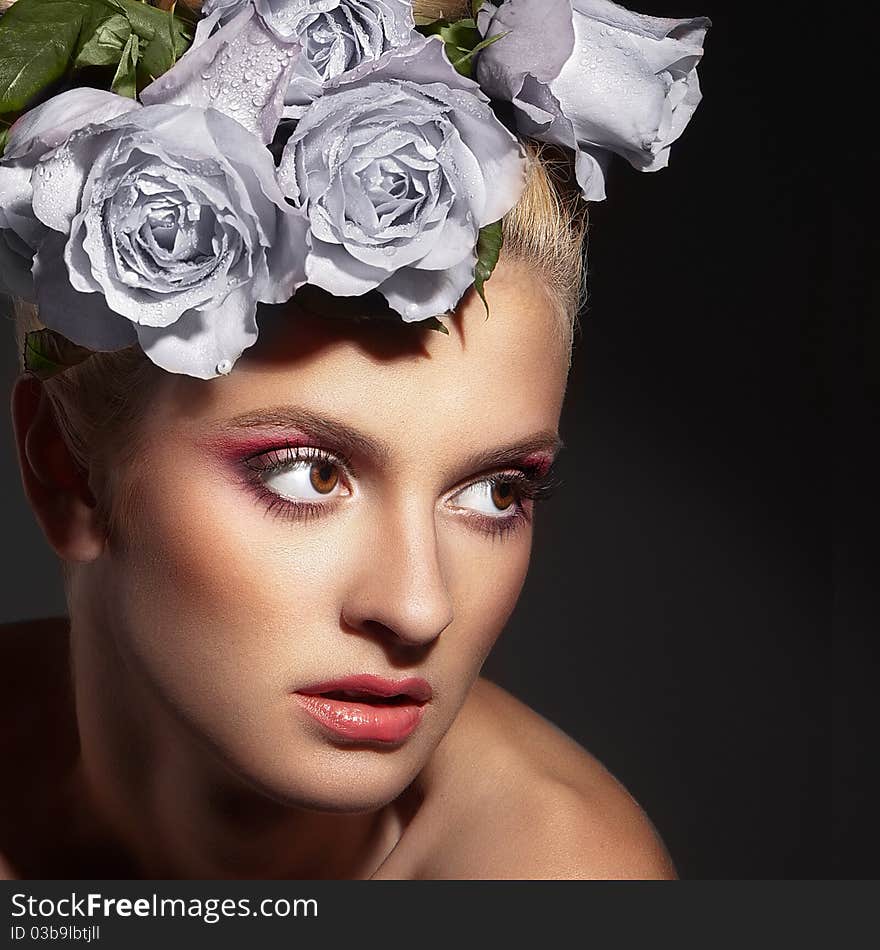 Portrait of a beautiful young woman with roses in her hair. Portrait of a beautiful young woman with roses in her hair