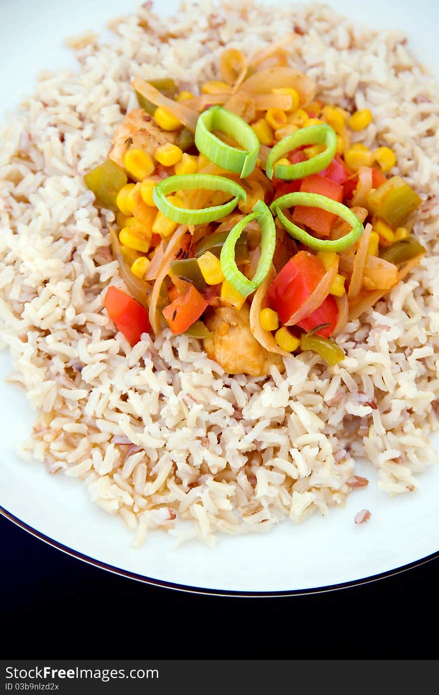 Appetizing rice dish on white plate on black background