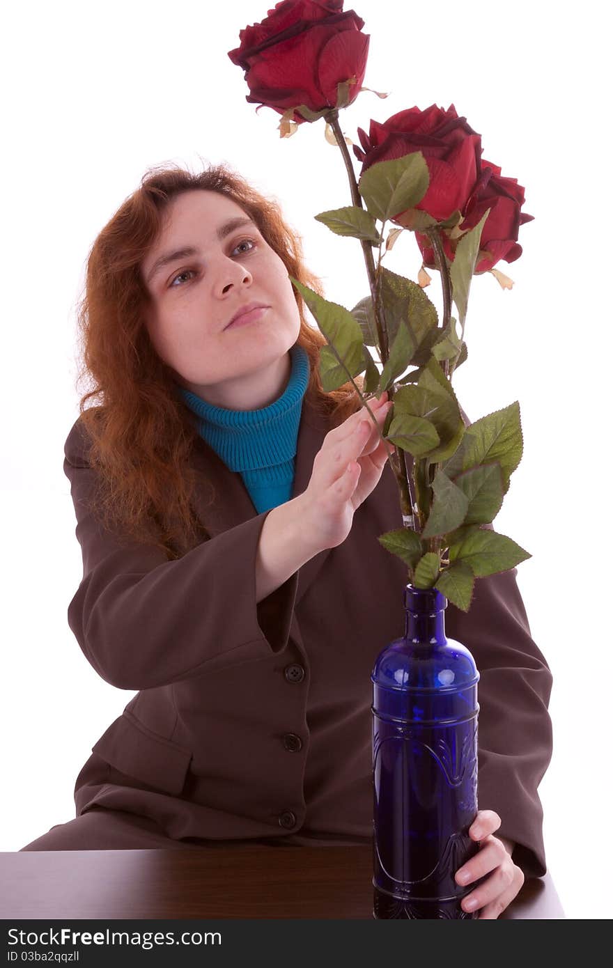 A young woman is arranging flowers in a vase. A young woman is arranging flowers in a vase