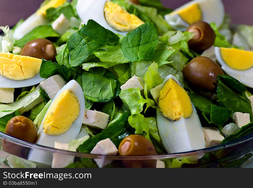 Romain Lettuce, Spinach, Tofu, Eggs and Green Olives in a Glass Bowl. Romain Lettuce, Spinach, Tofu, Eggs and Green Olives in a Glass Bowl