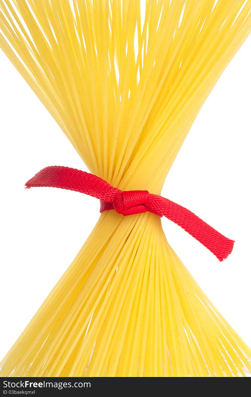 Bunch of spaghetti tied up with red ribbon isolated on white