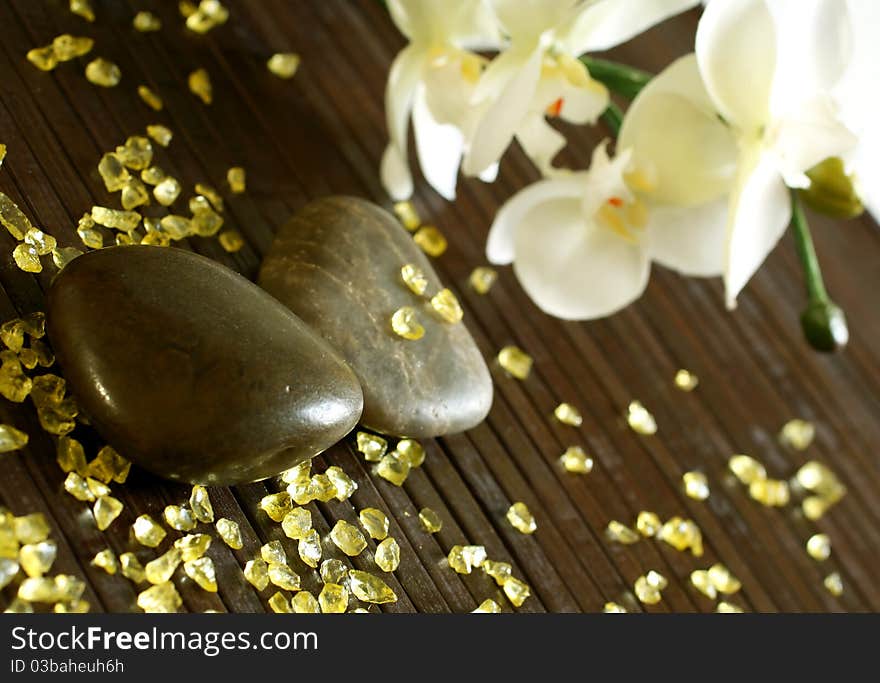 Stones, bath salts and orchid flower on wooden