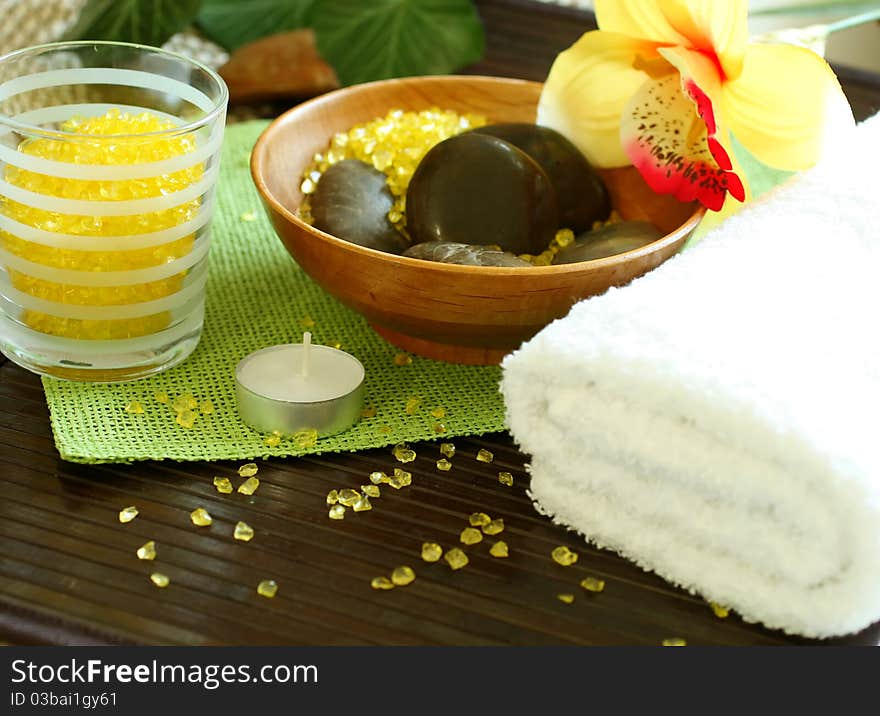 Spa composition of towel, stones and candle on wooden