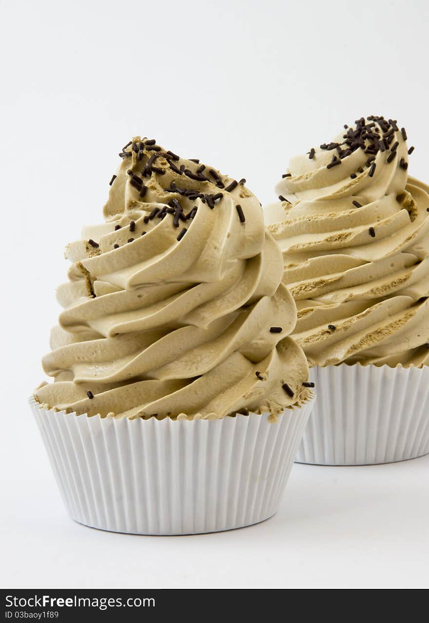 Close-up of two coffee meringues with chocolate chips on white background