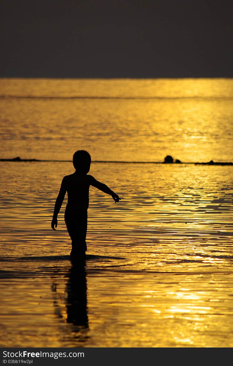 A boy wade into the sea, Chang Island, Trad, Thailand. A boy wade into the sea, Chang Island, Trad, Thailand