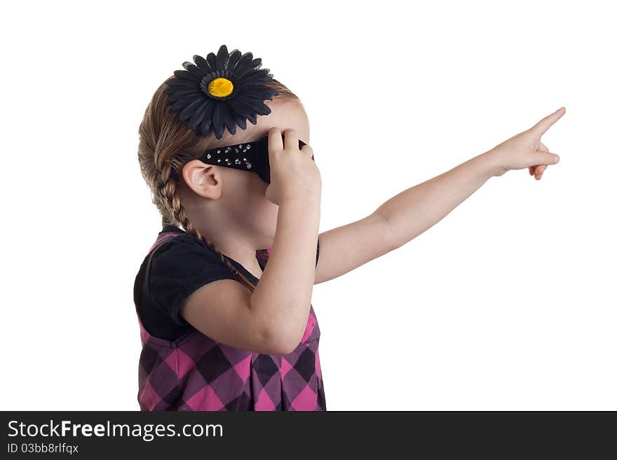 A girl pointing up in the are at something, as she grabs at her sunglasses to remove them. A girl pointing up in the are at something, as she grabs at her sunglasses to remove them.