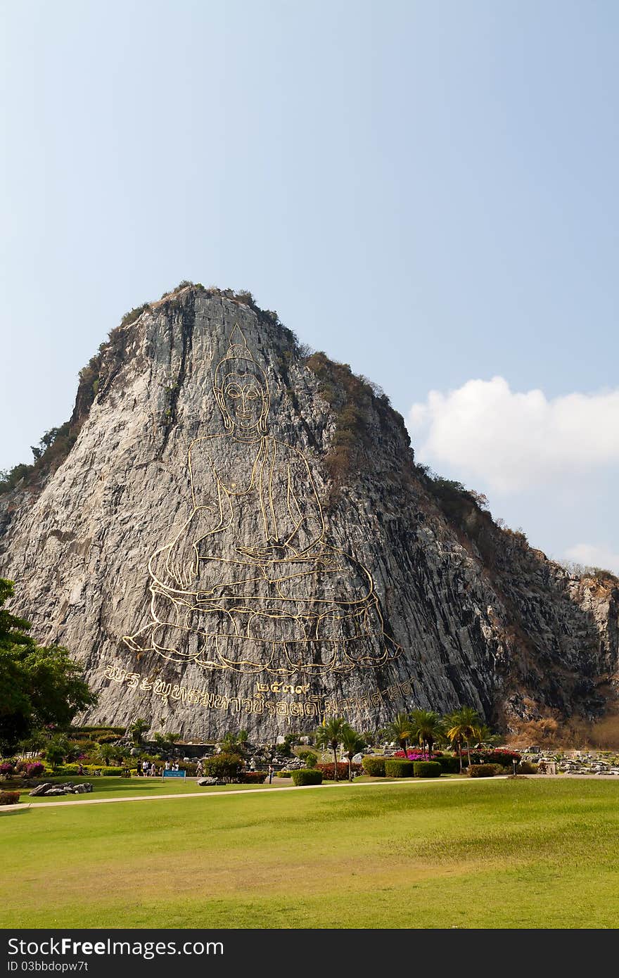 Gold painting of buddha statue on cliff