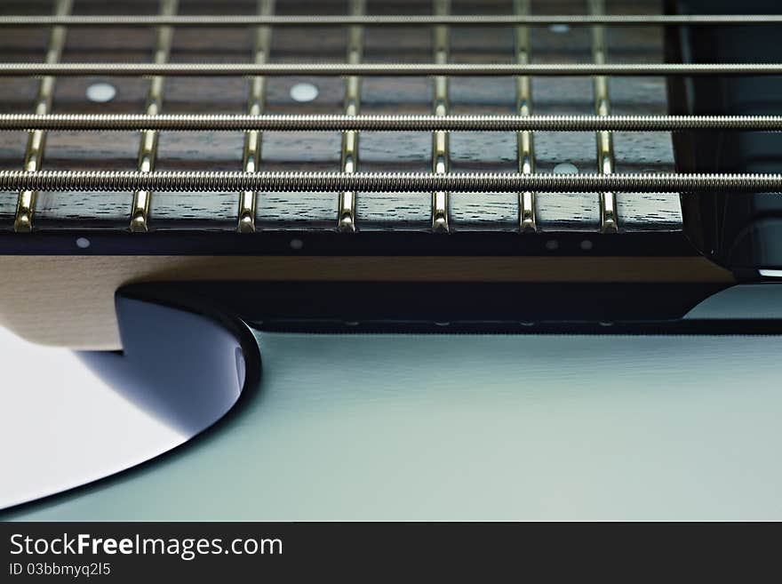 Closeup of five cords electric bass and fretboard. Horizontal shape, studio shot, copy space. Closeup of five cords electric bass and fretboard. Horizontal shape, studio shot, copy space