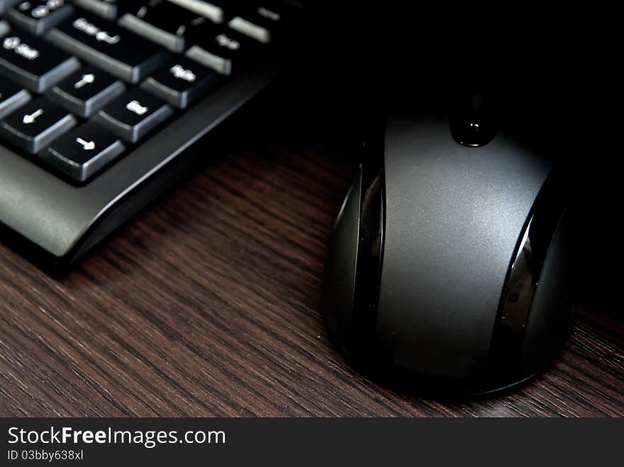 Black keyboard and mouse on a dark desk.