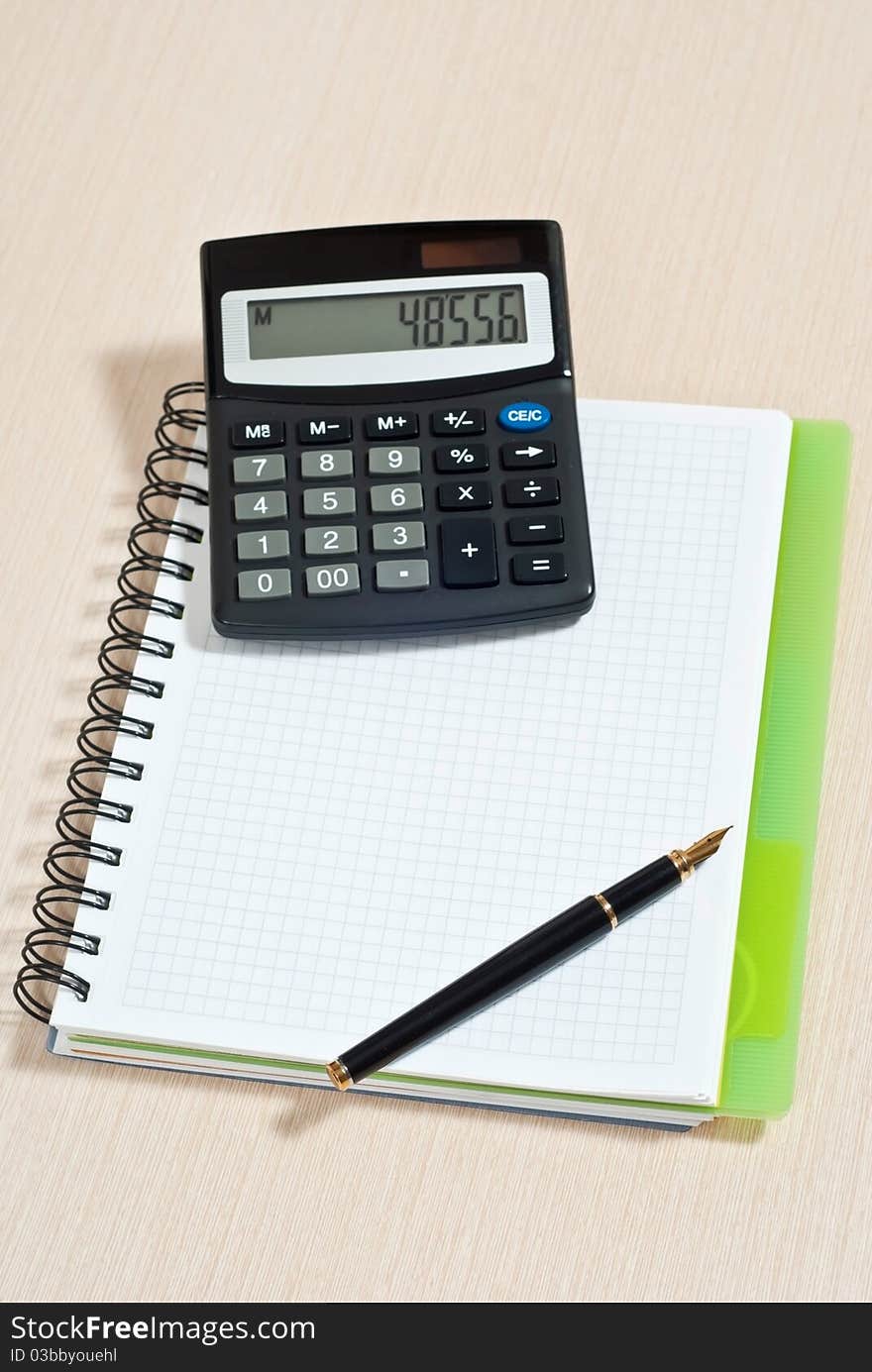 Notebook, ballpen and calculator on wooden desk. Notebook, ballpen and calculator on wooden desk