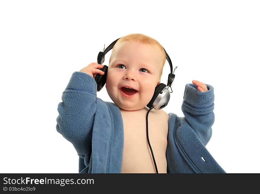 Small child in a bathrobe with headphones, smiling. Small child in a bathrobe with headphones, smiling