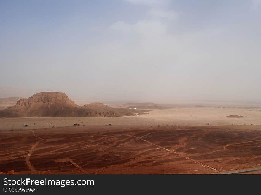 Mountain, surrounded by brown desert sand. Mountain, surrounded by brown desert sand