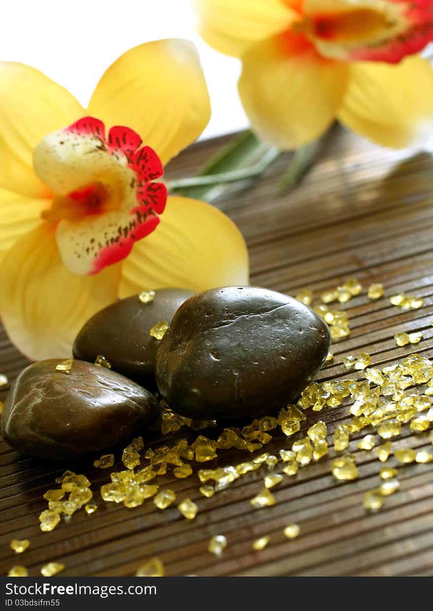 Spa composition of stones, yellow bath salt and flowers