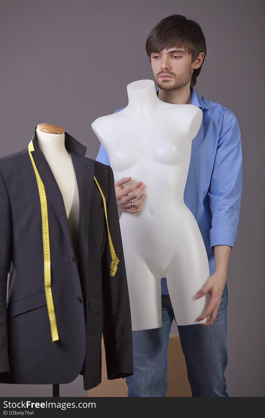 Male tailor with mannequin working in his studio. Male tailor with mannequin working in his studio