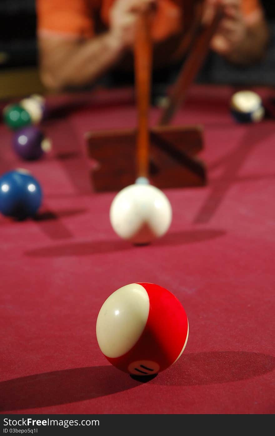 Snooker player taking a long shot across the table (focus on the first ball). Snooker player taking a long shot across the table (focus on the first ball)