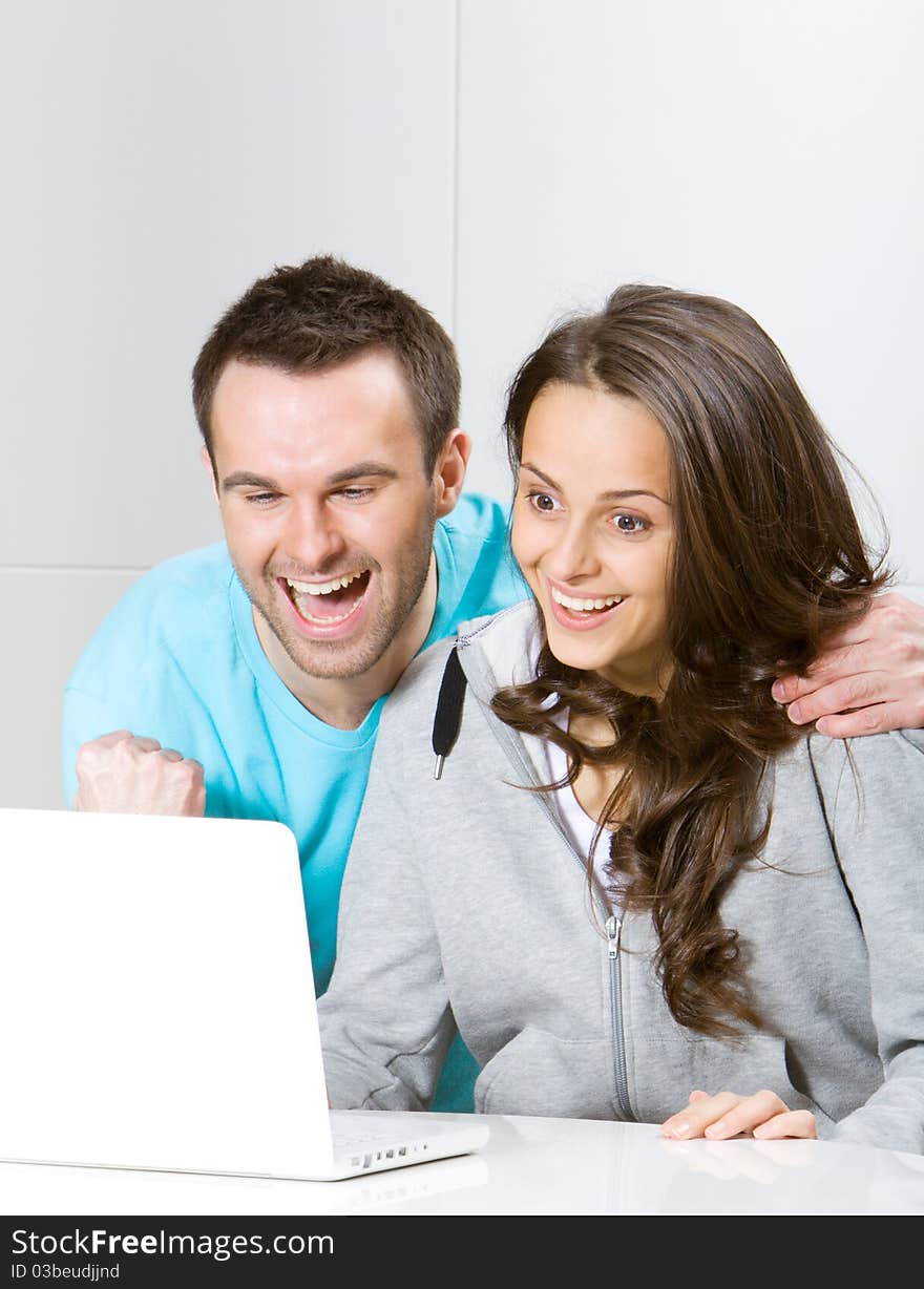 Happy young couple using laptop