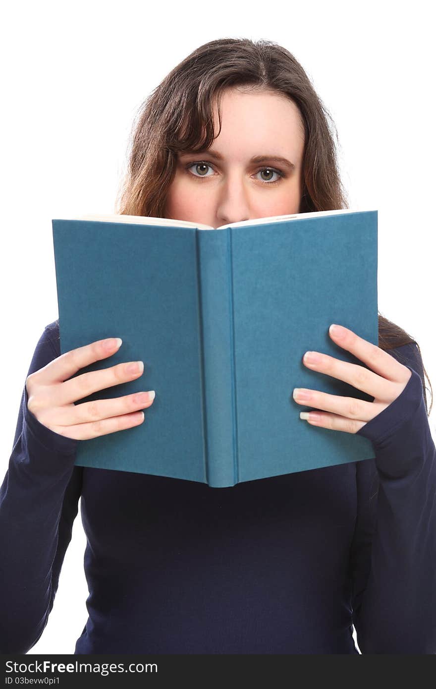 Young brunette woman looking up from behind a book she is reading. Young brunette woman looking up from behind a book she is reading.