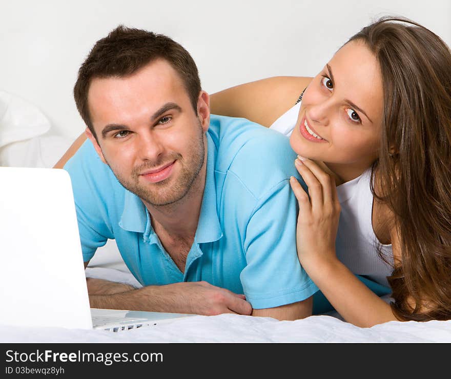 Young couple with laptop in white interior. Young couple with laptop in white interior