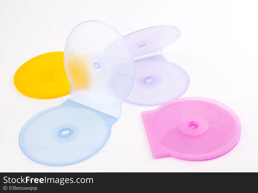 Colorful plastic cd covers spread out on a white background