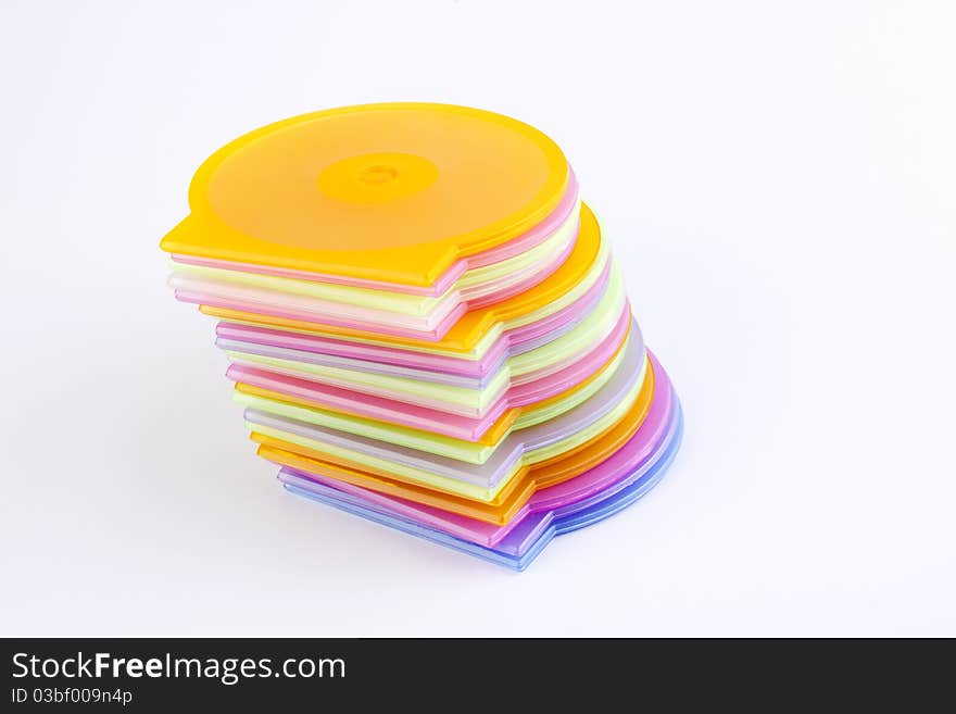 Colorful plastic cd covers stacked up out on a white background