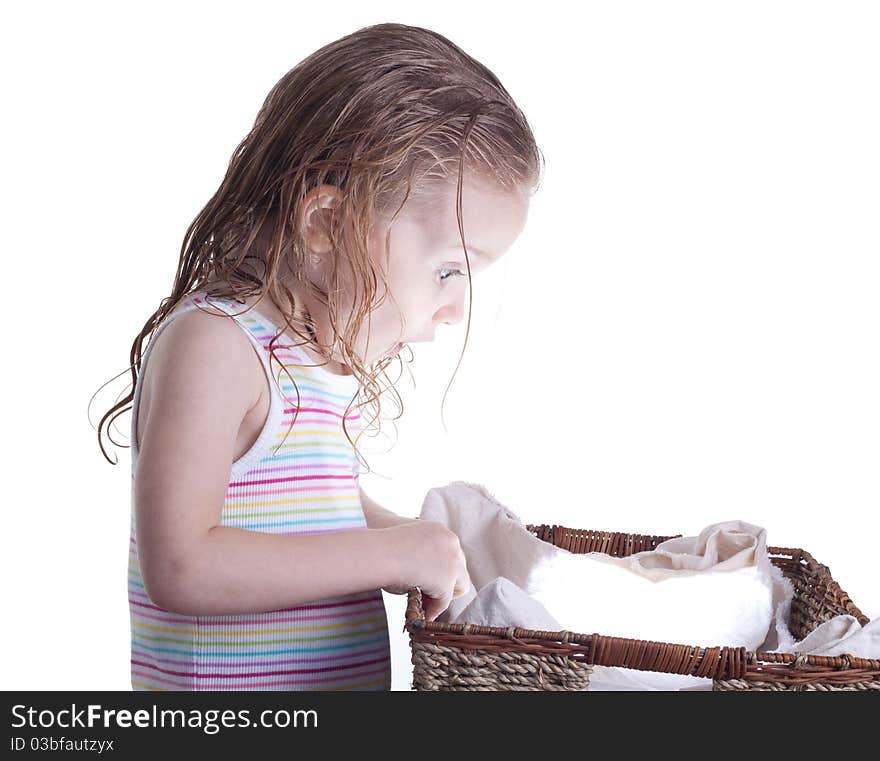 An excite young girl looking into a basket.  The basket is glowing with a ball of light or something inside of it.