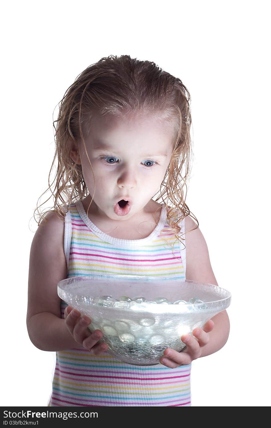 A young child is excited and enchanted by the ball of light glowing in the glass bowl she is holding. A young child is excited and enchanted by the ball of light glowing in the glass bowl she is holding.