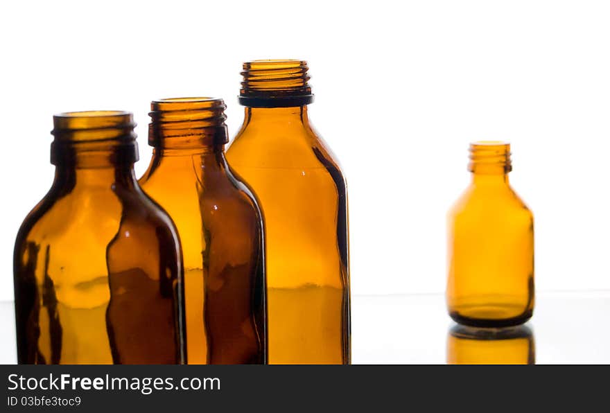 Four yellow glass bottles from under medicines on a white background