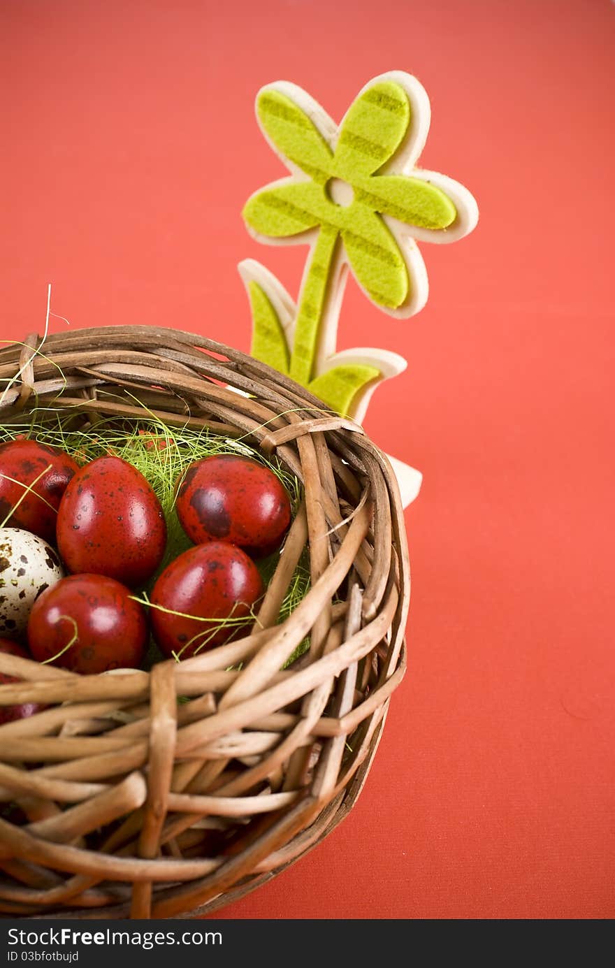 Easter eggs in wicker basket on red background