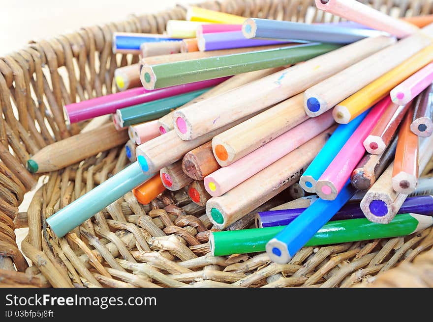 A heap of colour pencils in a basket. A heap of colour pencils in a basket