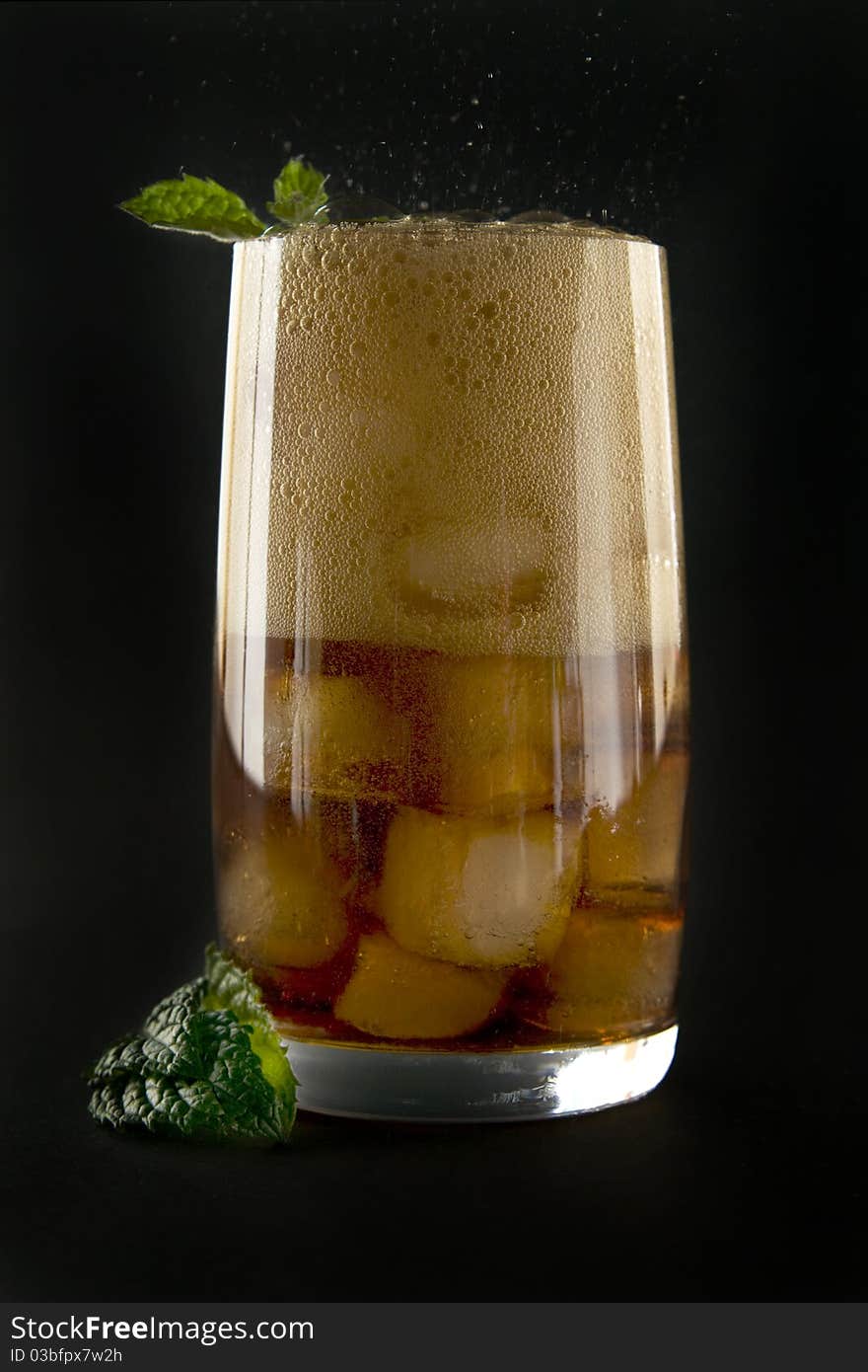 Glass with cola ice and mint on black background. Glass with cola ice and mint on black background.