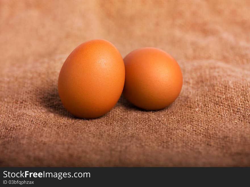 Two eggs on a brown background