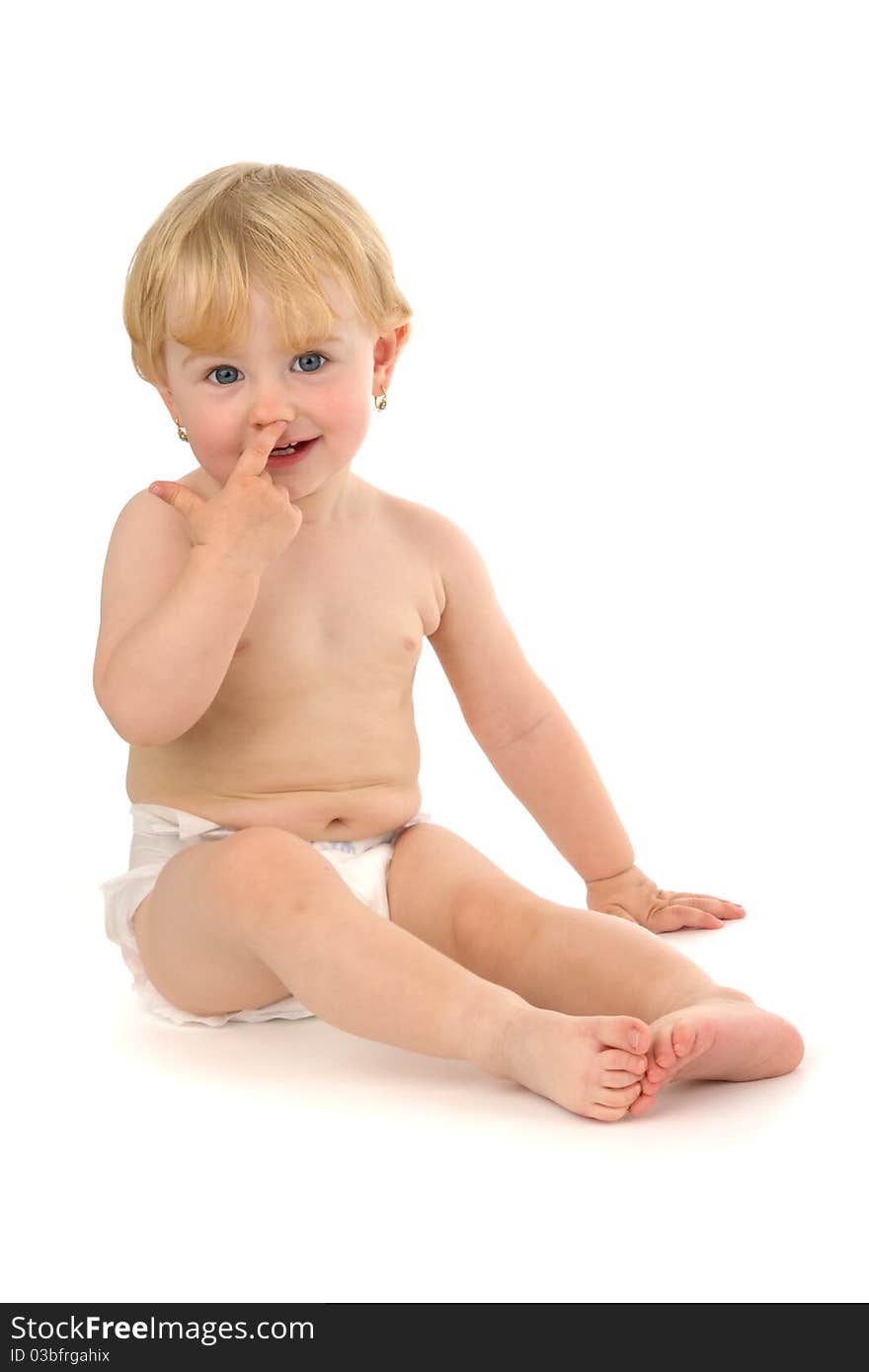 Infant sits and concerning finger personal nose, on white background.