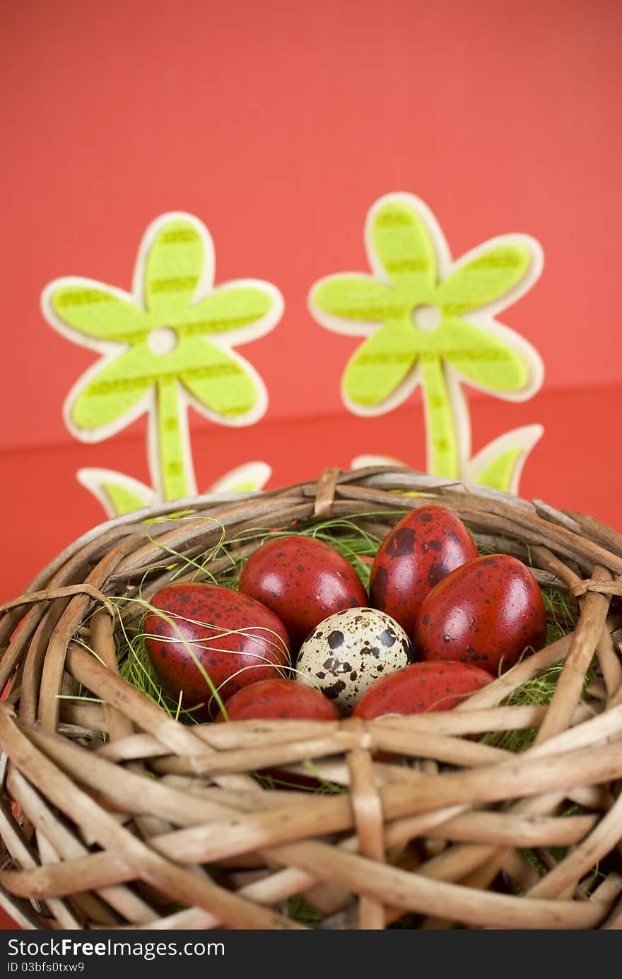 Easter eggs in wicker basket on red background