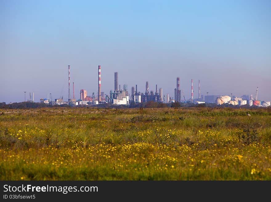 A distant oil and chemical refinery seen through a heat/pollution haze