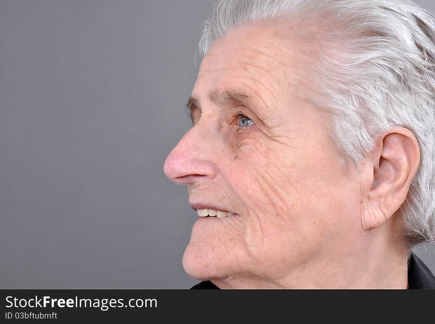 Old, attractive Caucasian woman looking off into the distance.