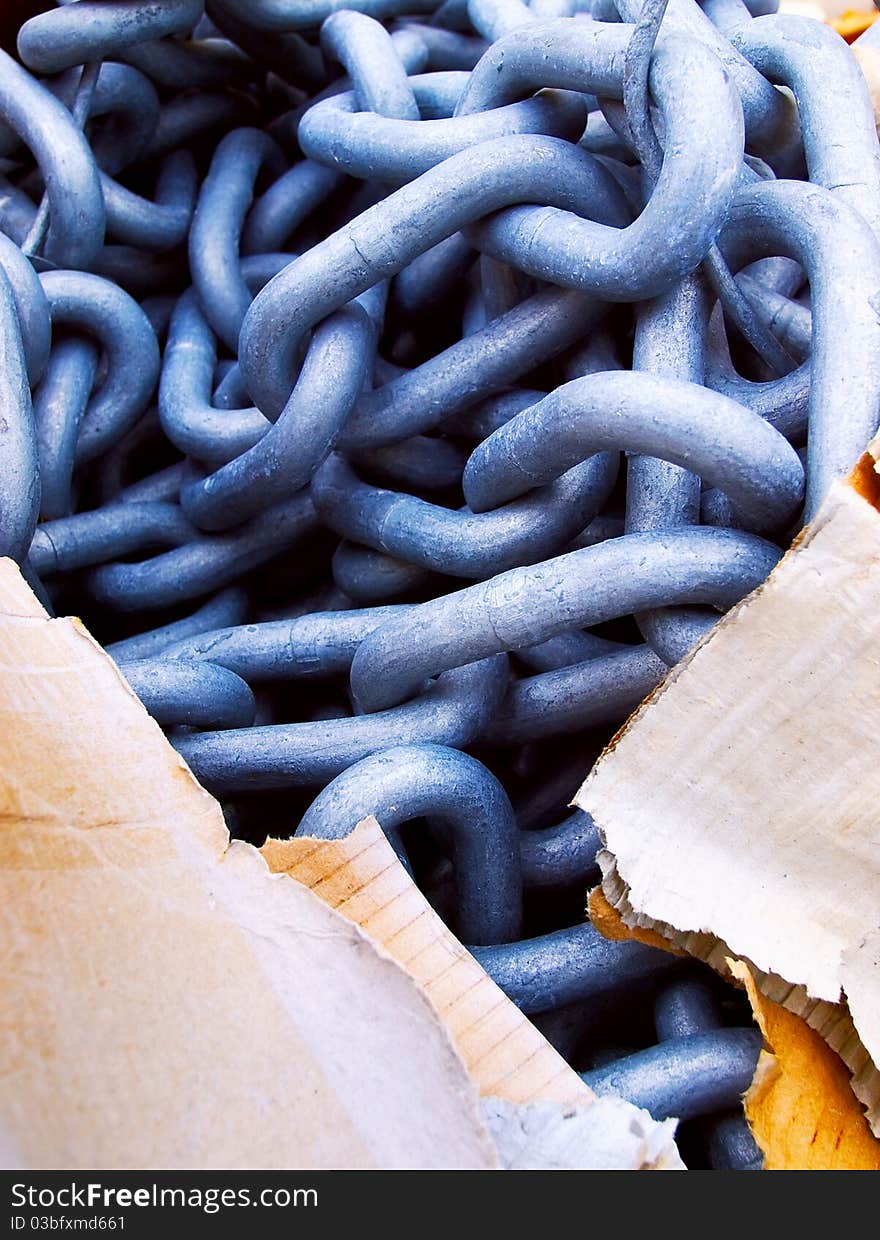 Bluish thick steel chain and cardboard packaging, contrast solid and tearable. Bluish thick steel chain and cardboard packaging, contrast solid and tearable