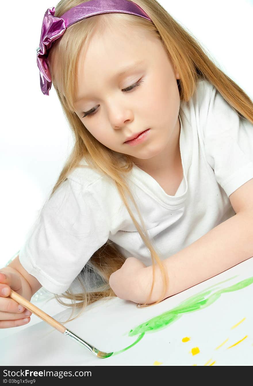 Cute little girl with a brush and paints