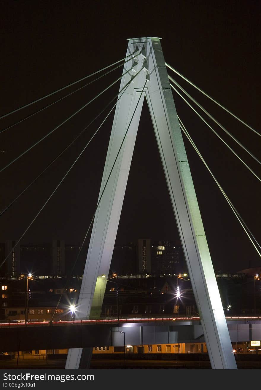 A dramatic night shot of the Severinsbrucke bridge in Cologne across the Rhine from the famous cathedral