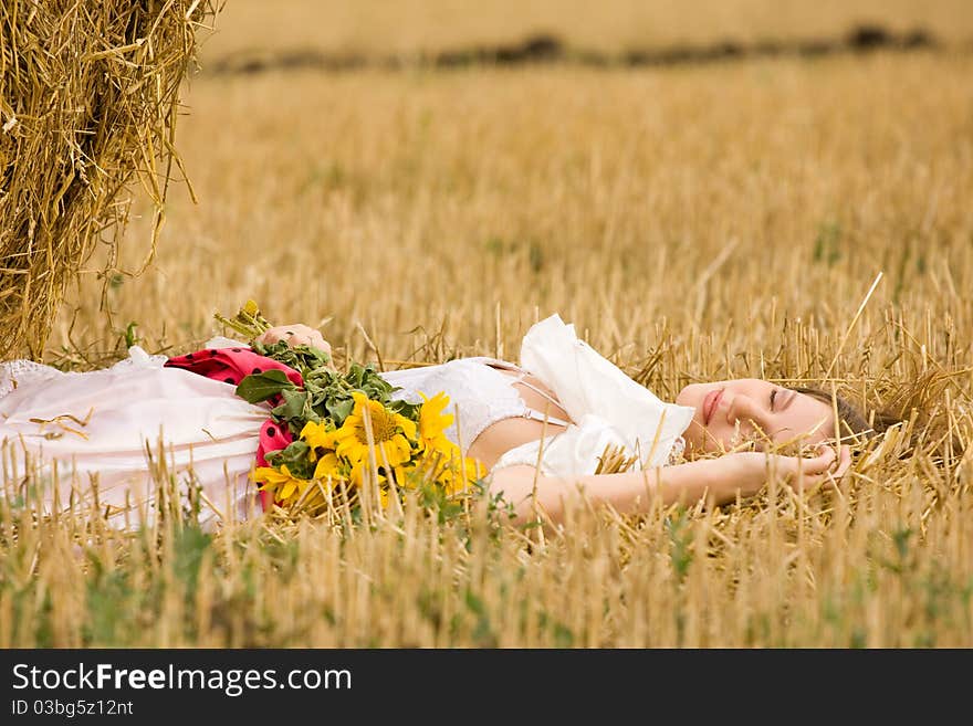 Woman in dress with flowers in the field. Woman in dress with flowers in the field