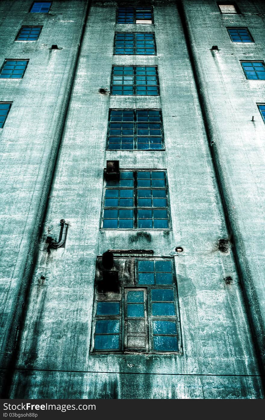 Sinister old abandoned dark blue building with blue windows. Sinister old abandoned dark blue building with blue windows