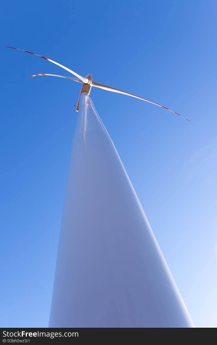 An image of wind turbine against blue sky