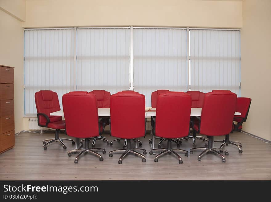 Conference table with a red leather armchair