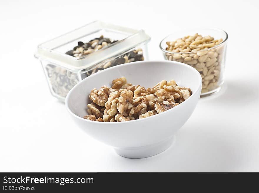 Mix of different nuts and seeds arranged on a white table. Mix of different nuts and seeds arranged on a white table