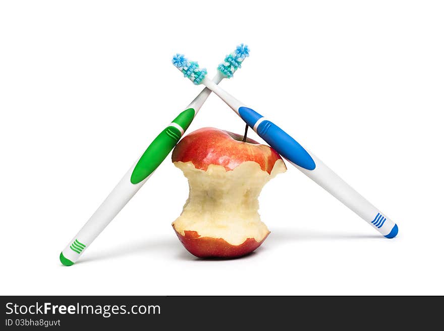 Two toothbrushes and an apple on a white background