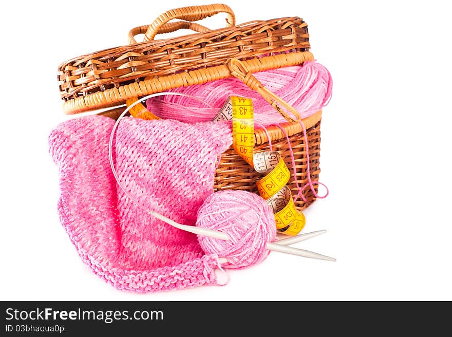 Handmade needle knitted pink canvas, yarn ball and and measuring tape inside basket. Handmade needle knitted pink canvas, yarn ball and and measuring tape inside basket