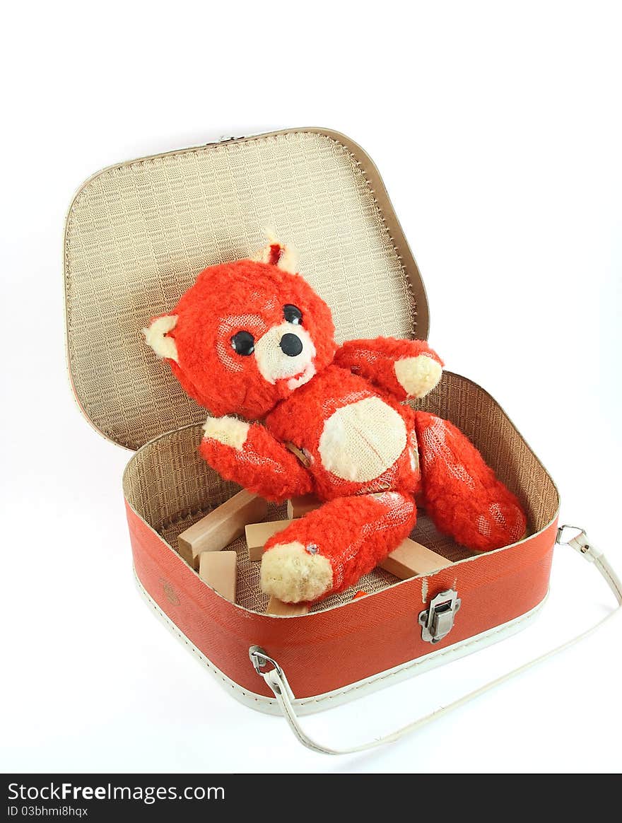 A small old suitcase and worn teddy bear on white. A small old suitcase and worn teddy bear on white