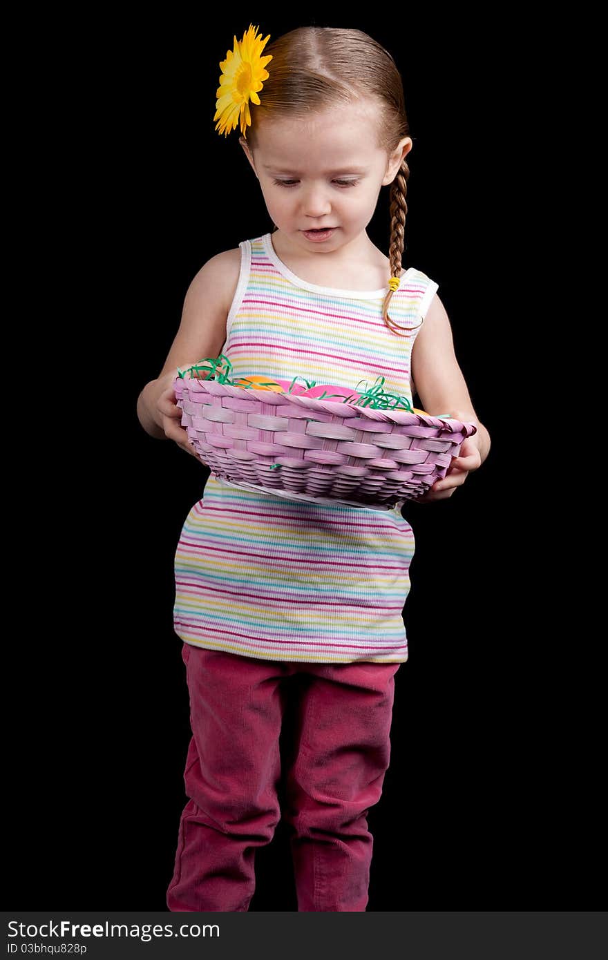 A beautiful young child looks in her pink easter basket. She could be counting her eggs before there hatched!. A beautiful young child looks in her pink easter basket. She could be counting her eggs before there hatched!