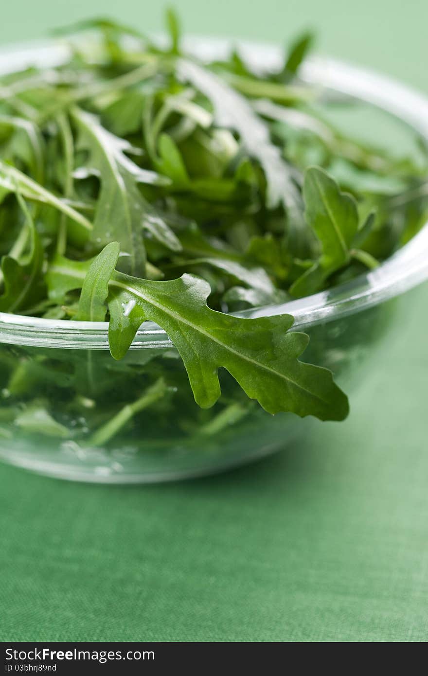 Green rucola fresh salad in glass bowl