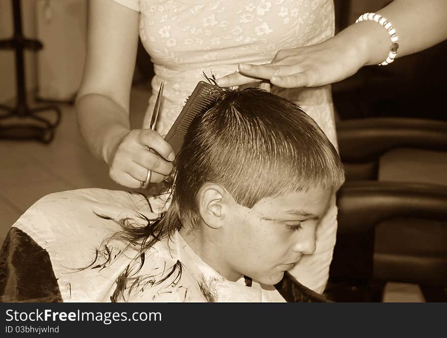 Caucasian boy getting a haircut sepia tones. Caucasian boy getting a haircut sepia tones