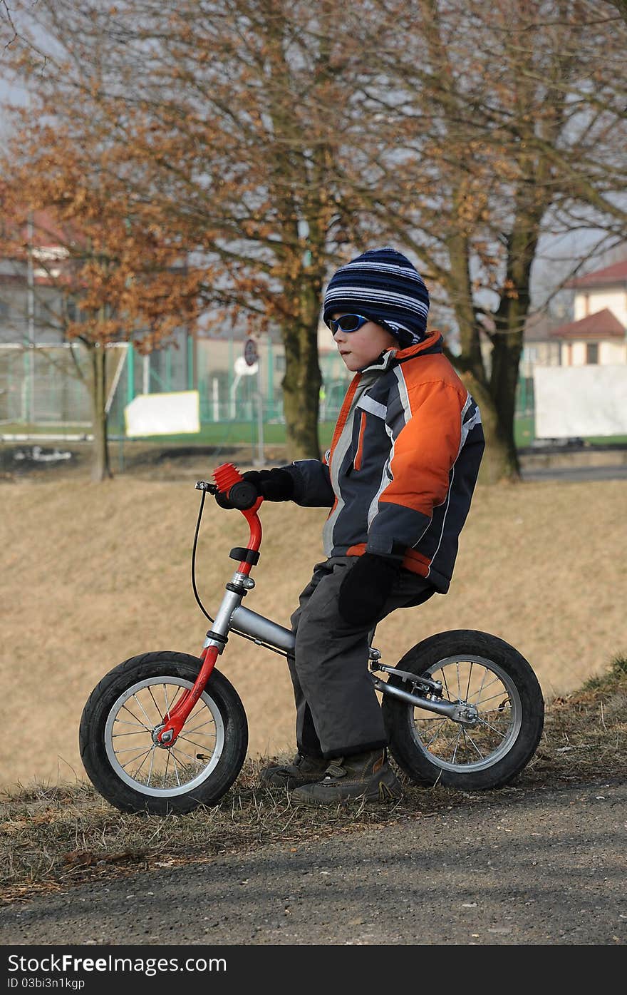 Young child sitting on a children bicycle and looking forward. Young child sitting on a children bicycle and looking forward